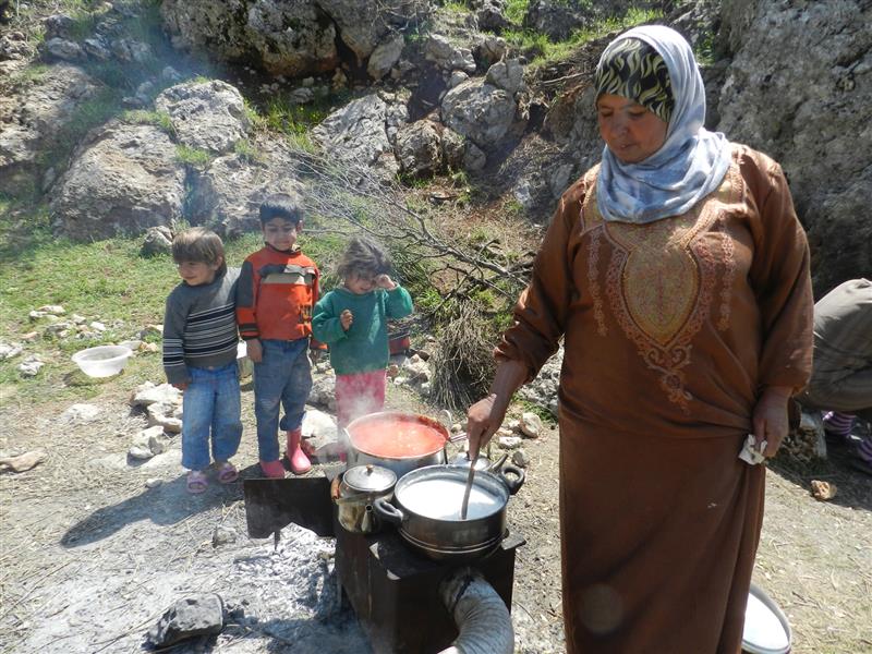 نازحة تحضر طعام الغداء في الهواء الطلق (طارق أبو حمدان)