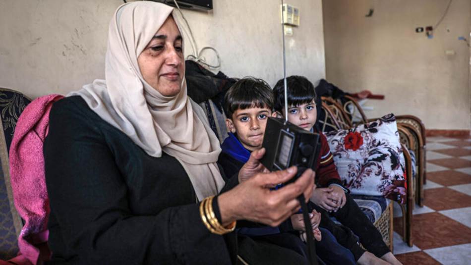 فلسطينية تستمع إلى الإذاعة في رفح (غيتي)